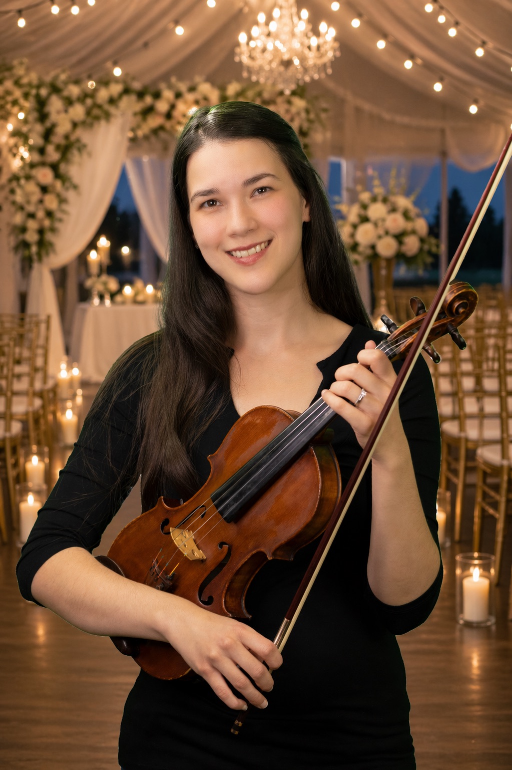 Mari, featured violinist for Miami Event Musicians, holding her violin at a candlelit wedding ceremony
